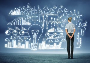 A person stands facing a large transparent screen filled with glowing business charts, graphs, and diagrams, symbolizing future-ready data analysis and strategy planning.